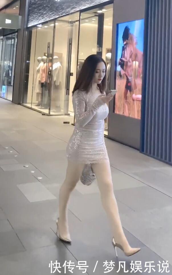 打扮精致的街头美女，泛光短裙配尖嘴高跟，时尚有个性