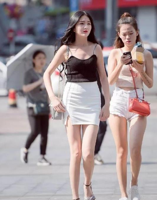 街拍艳冶柔媚的小姐姐,身穿长款上衣配短裤,笑容甜美可爱