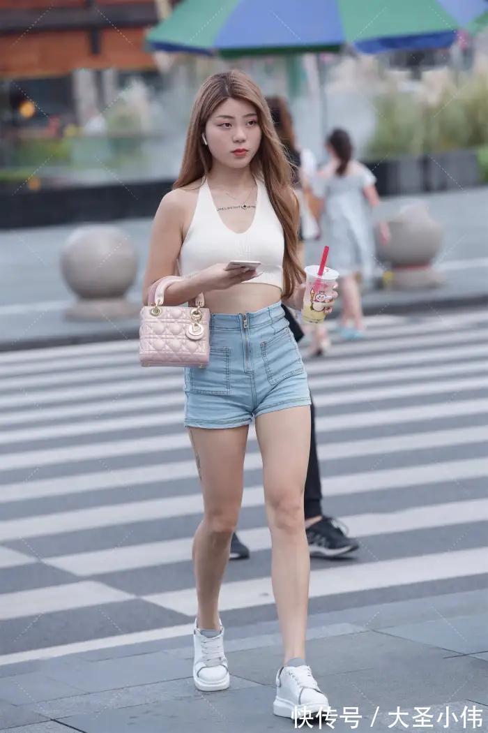 黄金比例|美女街拍:白色挂脖式针织上衣,搭配牛仔短裤和小白鞋,时尚性感又减龄好看