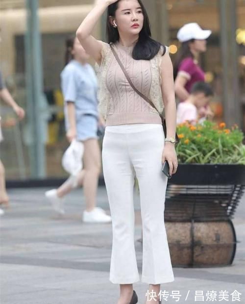 破洞牛仔裤 杏色的针织无袖衫,配高腰的白色雪纺喇叭裤,穿出了身材的美