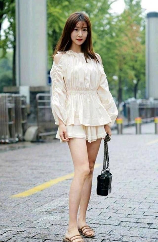 路人街拍，美女穿着一件v领的吊带，为自身的美丽加分