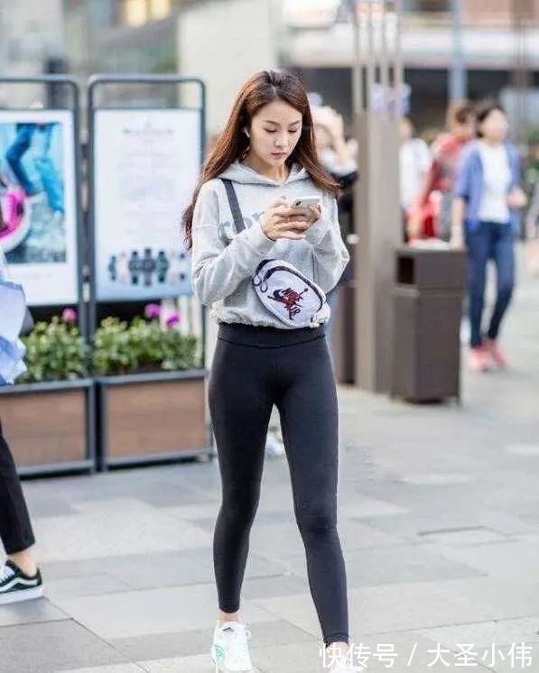 露脐短袖 美女街拍:白色露脐短袖搭配黑色打底裤,可爱显瘦,年轻女孩的必备穿搭