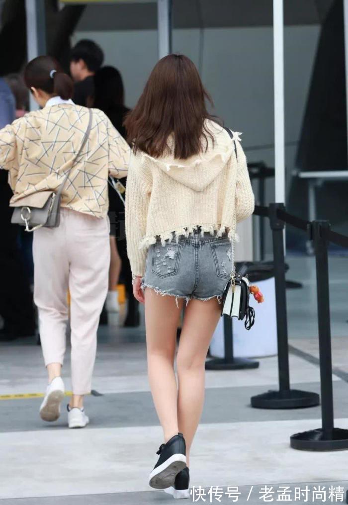 手机 街拍:米黄毛衫搭牛仔热裤的靓丽女孩,走路也不忘玩手机很危险!