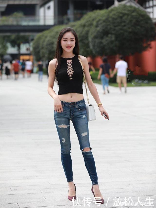 小姐姐一件黑色背心,搭配一条破洞牛仔裤,时尚大方有个性