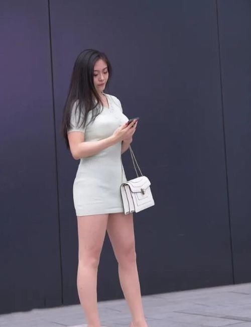 包臀型 绿色小V领连衣裙,展现出“S型身材”,白色时尚手提包,简约大方