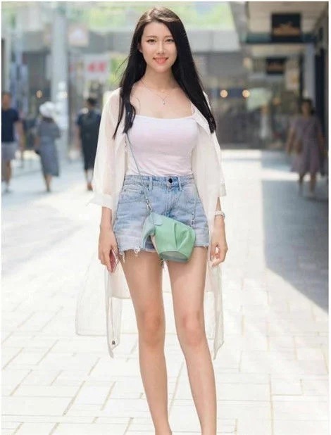 街拍:身材高挑的小姐姐,穿牛仔短裤,秀出大长腿和小蛮腰