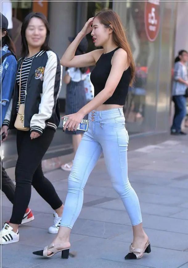 美女黑色无袖短款背心搭浅白色牛仔裤,在人群中具有非常明确显眼