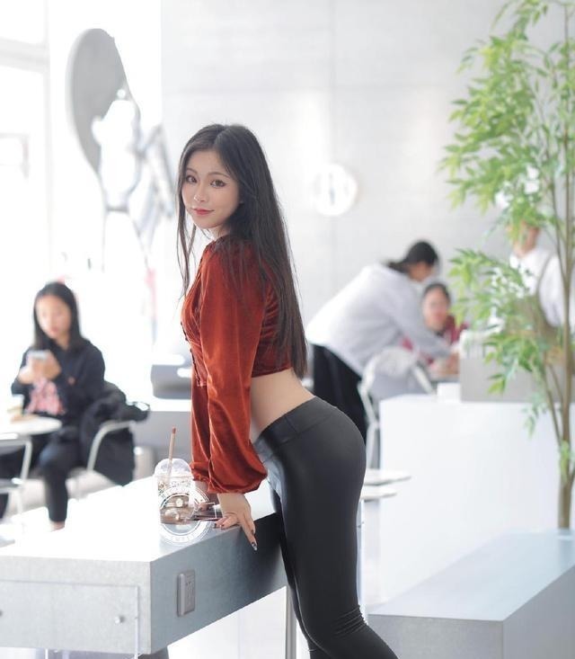 丝绒上衣 美女穿深褐色的丝绒上衣配皮裤,露出美丽腰线,散发出魅力