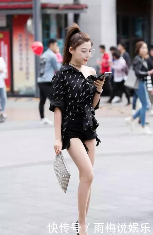 街拍小姐姐黑色的上衣搭配牛仔短裤，很显青春活力的气息