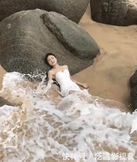 为了拍好婚纱照美女穿裙子躺海水里，下一刻却让美女尴尬