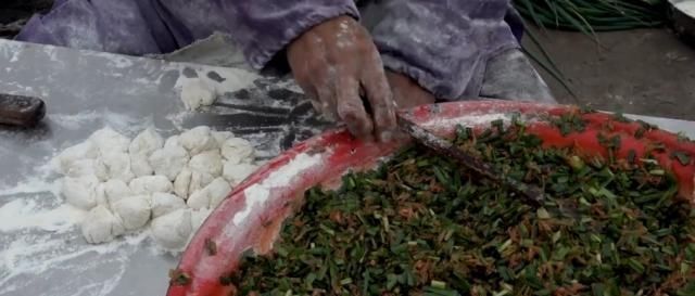 一位65岁老汉在大集卖小吃,露天柴火烧,顾客大老远跑来吃