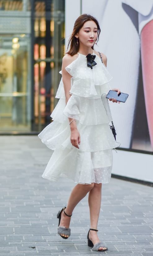 身穿蛋糕裙的小姐姐,裙身的版型立体,彰显出甜美俏皮的感觉